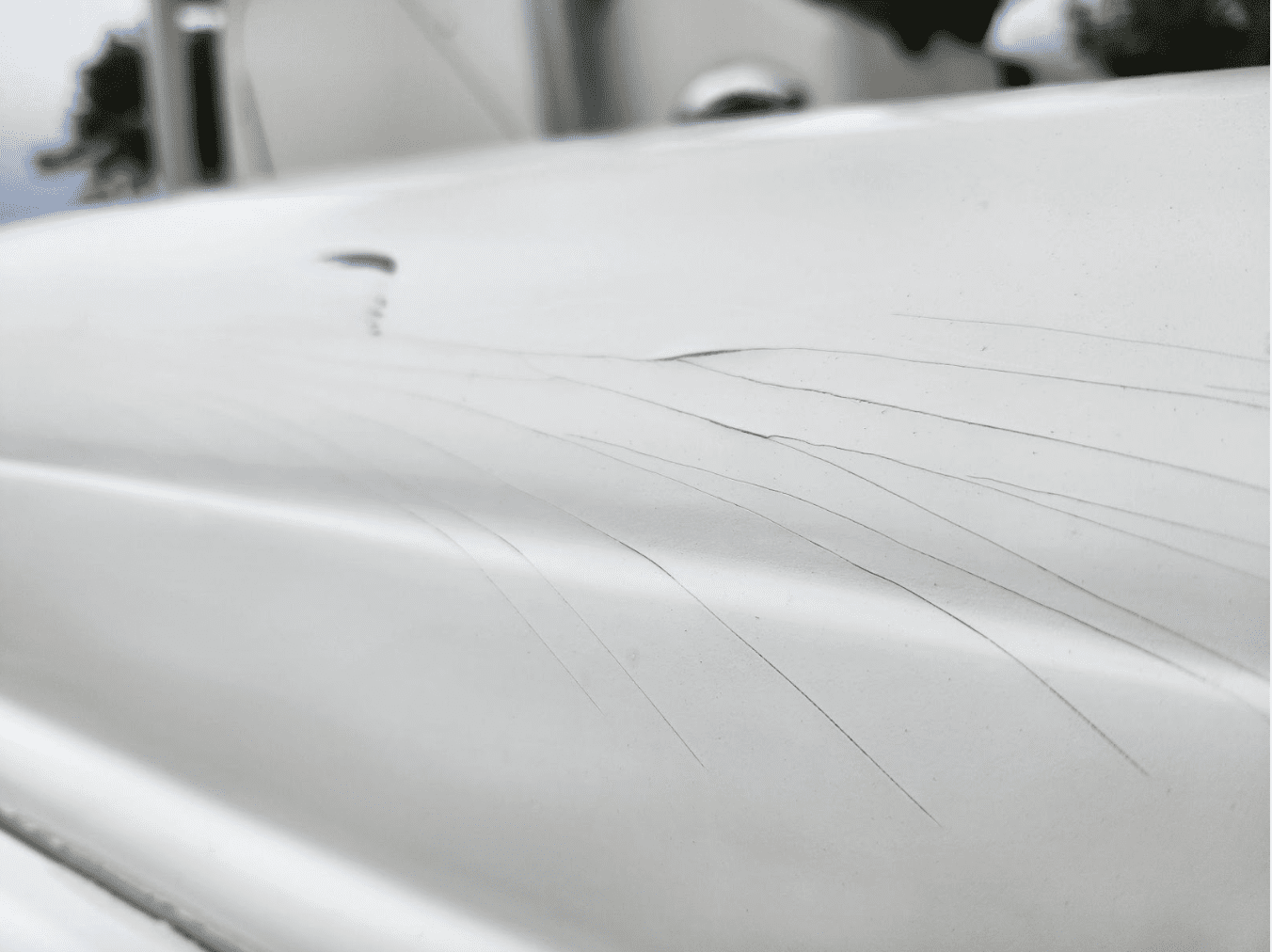 Screenshot 2025-08-16 at 12.57.48 PM Hairline cracks spanning from an impact to the boat’s surface